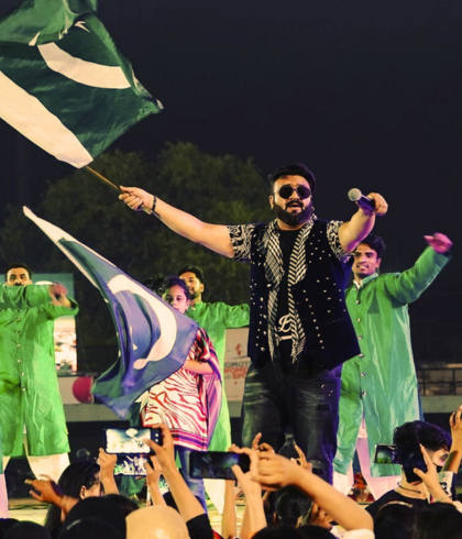Sahir Ali Baga standing in the crowd waving the Pakistani flag